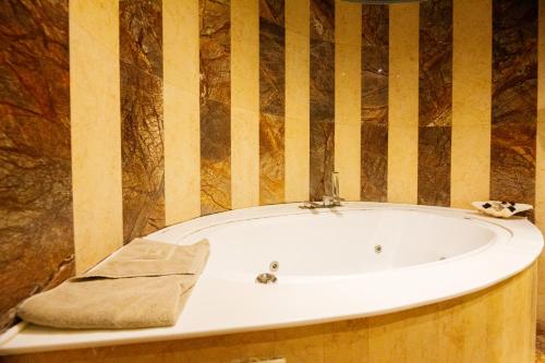 a bath tub with a towel sitting on top of it at Civitas Suites Hotel in Rethymno