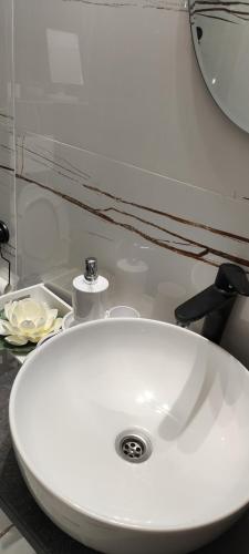 een witte wastafel in een badkamer met een spiegel bij Infinit relax in Târgu Jiu
