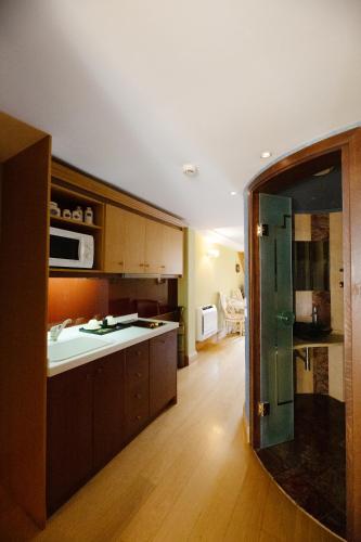 a kitchen with wooden cabinets and a glass door at Civitas Suites Hotel in Rethymno Town