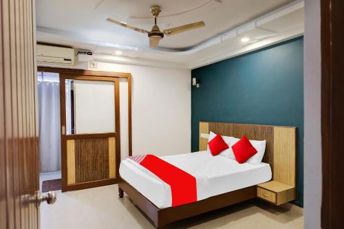 Un dormitorio con una cama con almohadas rojas. en Hotel O Sea View Inn, en Chennai