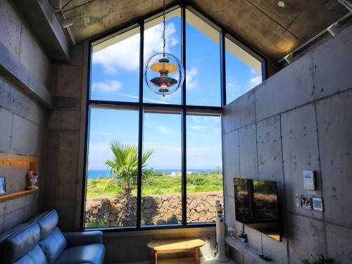 a room with a large window with a view of the ocean at Dalthor Pension in Jeju