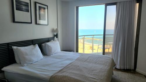 a bedroom with a bed with a view of the ocean at Herzliya Sea View Hotel Apartment in Herzliya