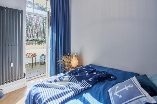 um quarto com uma cama com lençóis azuis e brancos em Apartamenty Świnoujście - Apartament Bella em Świnoujście