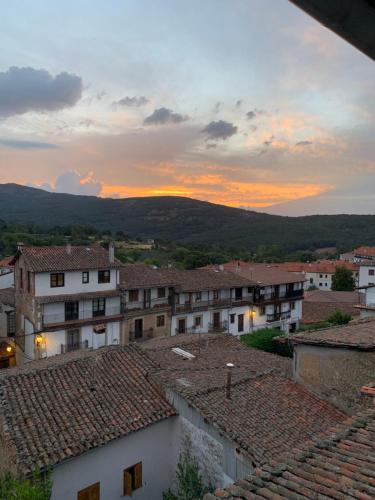 a view of a town at sunset with roofs at El Jardín del Laurel - only adults - in Candelario
