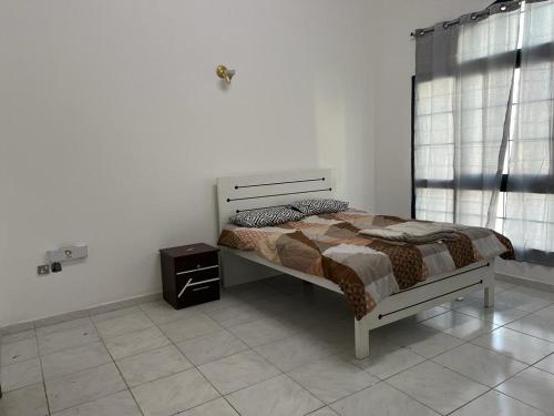 a bedroom with a bed in a white room at Al-Satwa Central Bliss: Ideal for Families in Dubai