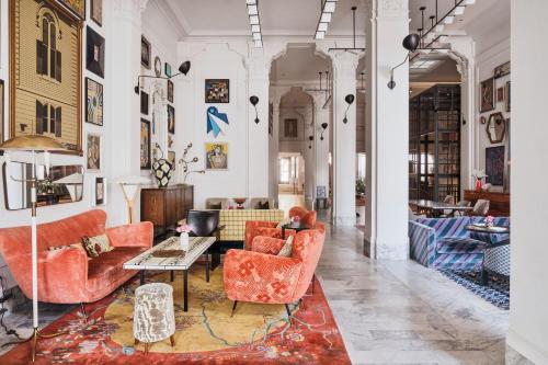 a living room with orange chairs and a table at San Francisco Proper Hotel, a Member of Design Hotels in San Francisco