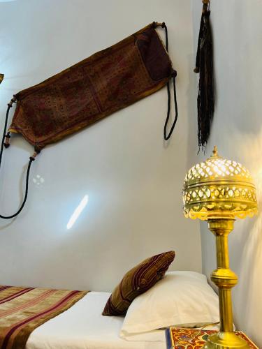 a bedroom with a bed and a lamp on the wall at Riad Al Nour in Marrakech