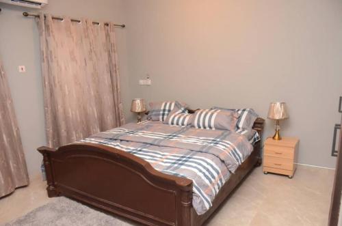 a bedroom with a bed with two lamps on it at Zegio Villa in Jomo