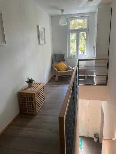 een kamer met een trap, een stoel en een raam bij Ferienwohnung Inga in Hasselfelde