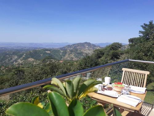 a table on a balcony with a view of the mountains at Bujtina Bezhani Gjinar in Elbasan