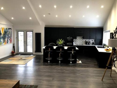 una cocina con armarios negros, mesa y sillas en Modern 2 bedroom town centre apartment in Tamworth en Tamworth
