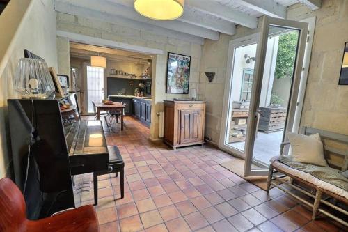 a living room with a piano and a kitchen at La Maison de Cerise in Fourques