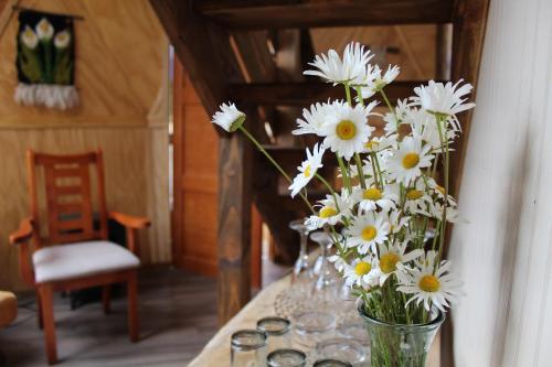 un jarrón lleno de flores blancas en una mesa en Lerun Sheg Lodge en Coihaique