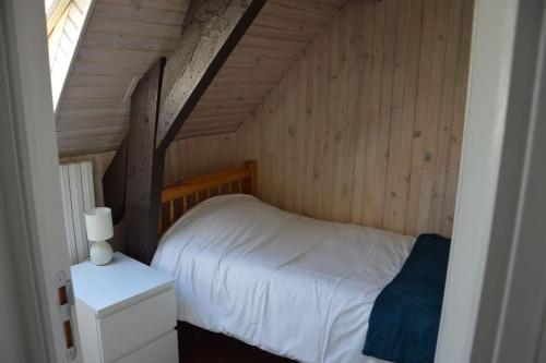 a bedroom with a bed in a wooden room at Ty ker Aziliz : maison de ville au calme in Dinan