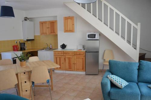 Il comprend une cuisine et un salon avec un canapé bleu. dans l'établissement Ty ker Aziliz : maison de ville au calme, à Dinan