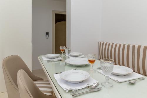 a table with plates and wine glasses on it at Mrs Kalis cottage in Andros