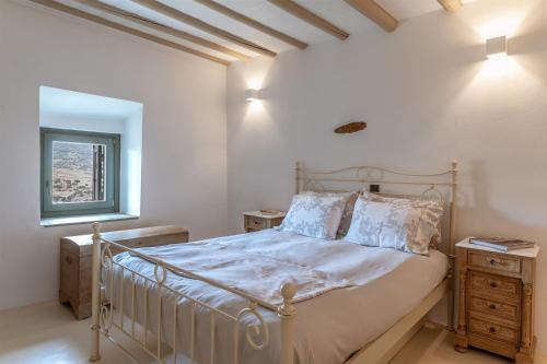 sypialnia z łóżkiem i oknem w obiekcie Mrs Kalis cottage w mieście Andros