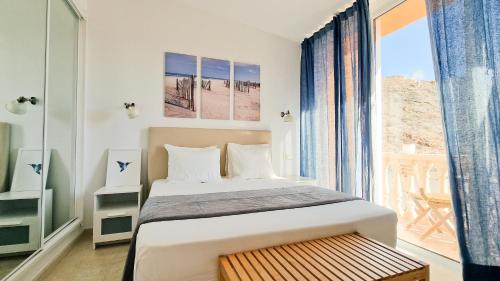 een slaapkamer met een bed en een groot raam bij Amazing cozy Villa Hugo Tauro with Jacuzzi, Pool, Wi-Fi in Mogán