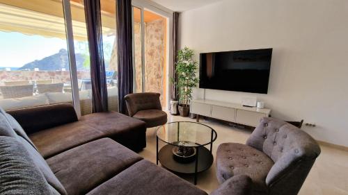 a living room with a couch and chairs and a tv at Amazing cozy Villa Hugo Tauro with Jacuzzi, Pool, Wi-Fi in Mogán