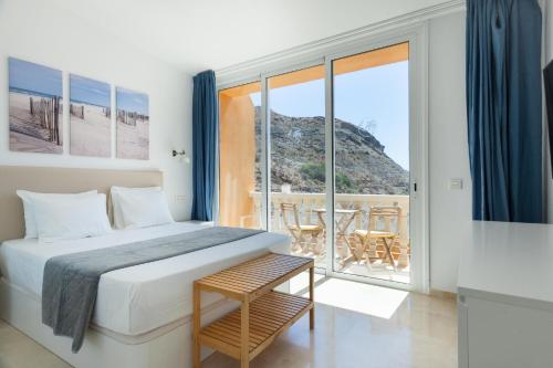 a bedroom with a bed and a large window at Amazing cozy Villa Hugo Tauro with Jacuzzi, Pool, Wi-Fi in Mogán
