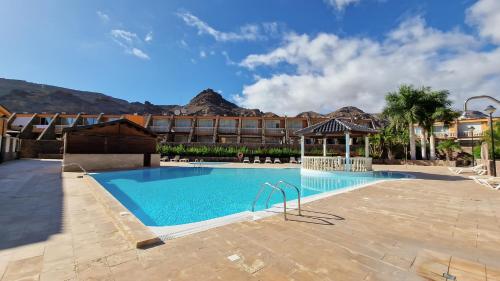 a large swimming pool in front of a hotel at Amazing cozy Villa Hugo Tauro with Jacuzzi, Pool, Wi-Fi in Mogán