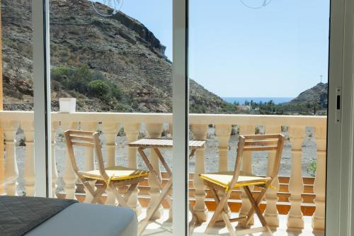a balcony with two chairs and a table on a balcony at Amazing cozy Villa Hugo Tauro with Jacuzzi, Pool, Wi-Fi in Mogán