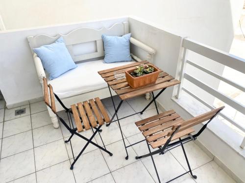 a small balcony with a bench and a table and chairs at Korona Beach Apartments I in Rethymno