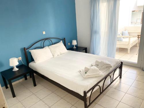 1 dormitorio con 1 cama con pared azul en Korona Beach Apartments I en Rethymno