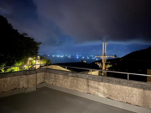 a night view of a bridge with a cross in the background at Slowly B&B in Jiufen