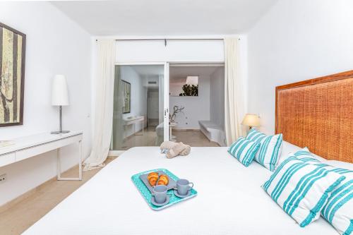 a white bedroom with a tray of fruit on a bed at Casa Birdie By Kura Homes in Marbella