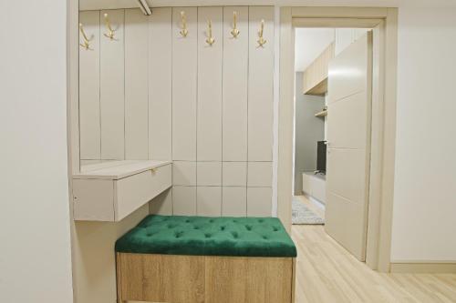 - une cuisine avec un pouf vert et un miroir dans l'établissement Himson-Green Apartment, à Iaşi