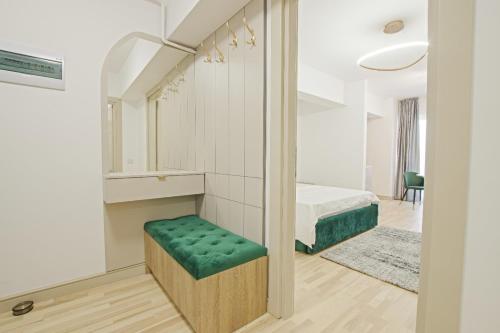 Cette chambre comprend un lit et un banc vert. dans l'établissement Himson-Green Apartment, à Iaşi