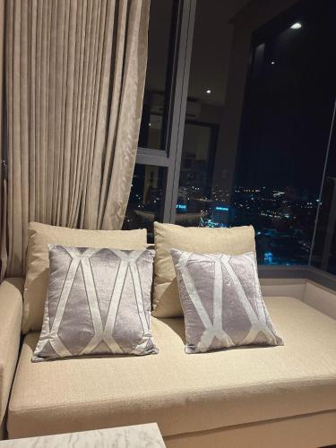 a couch with two pillows in front of a window at Once Pattaya Seaview Condo in Pattaya Central