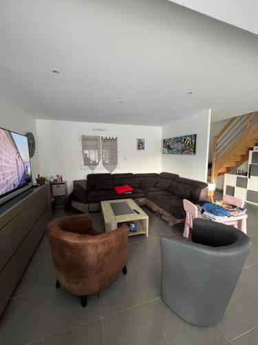 salon z kanapą i telewizorem z płaskim ekranem w obiekcie Chambre chez thomas w mieście Glos-sur-Lisieux