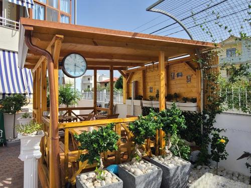 a gazebo with a clock and some plants at My Apartments Durres in Durrës