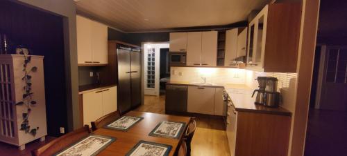 eine Küche mit einem Tisch und eine Küche mit einem Kühlschrank in der Unterkunft Riverside country house in Rovaniemi