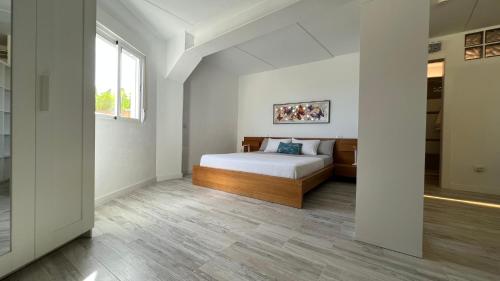 um quarto branco com uma cama e uma janela em Parque La Luz em La Orotava