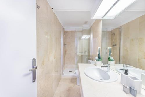a bathroom with two sinks and a shower at Casa Birdie By Kura Homes in Marbella