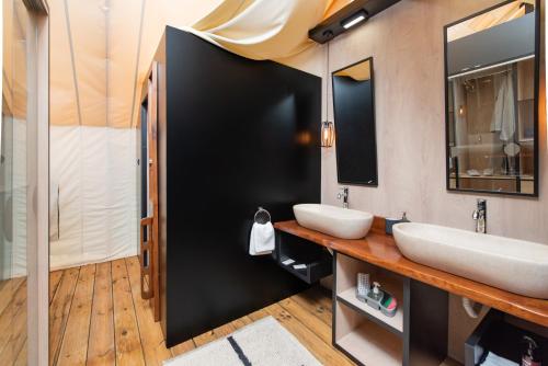 a bathroom with two sinks and a mirror at Floria Glamping Garden in Labin