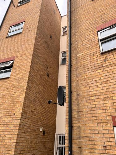 um edifício de tijolos com uma placa na lateral em Grey Eagle Apartments Shoreditch em Londres