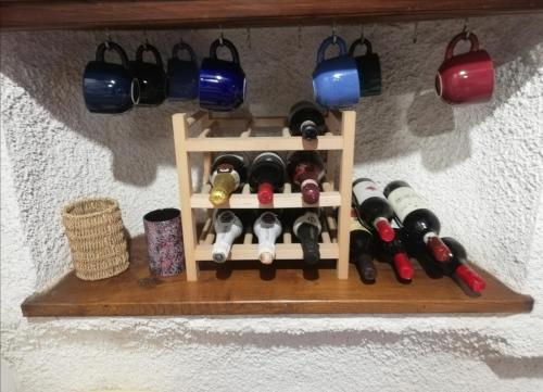 a wooden wine rack with wine bottles on a wall at Appartamento Iesa in Lama