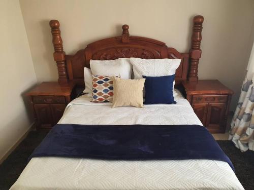 a bed with blue and white sheets and pillows at Stunning 3-Bed House in Harare in Harare