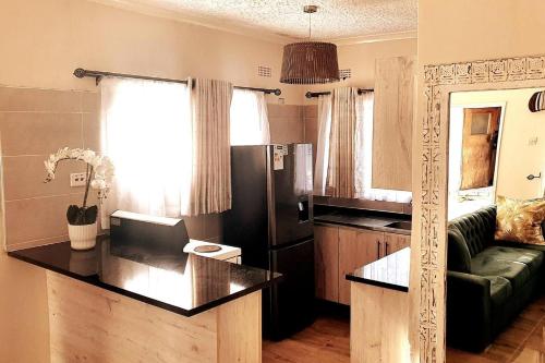 a kitchen and living room with a black refrigerator at Stunning 3-Bed House in Harare in Harare