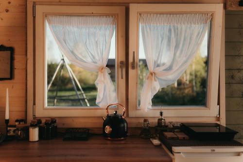 a kitchen with two windows with white curtains at Ambercoast in Jūrmala