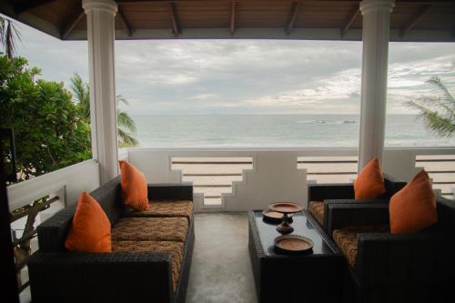 a porch with couches and a view of the ocean at Sea Crest Beach Villa in Ambalangoda