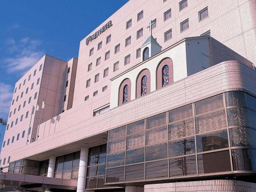 - un grand bâtiment blanc avec des fenêtres sur le côté dans l'établissement Matsuzaka Frex Hotel, à Matsuzaka