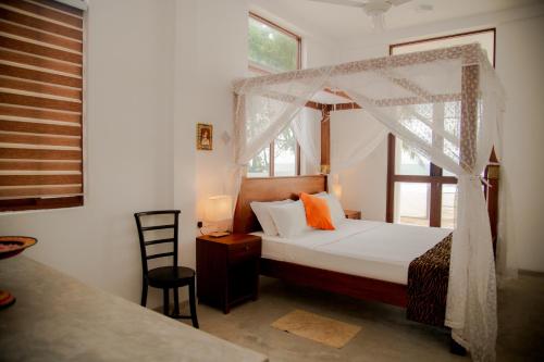 a bedroom with a canopy bed and a window at Sea Crest Beach Villa in Ambalangoda