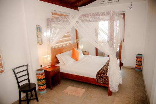 a bedroom with a bed with a mosquito net at Sea Crest Beach Villa in Ambalangoda