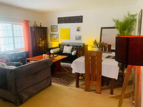 a living room with a couch and a table at harmonious two bed cottage with breathtaking views in Kajiado
