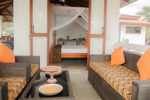 a room with a bed and a couch and a table at Sea Crest Beach Villa in Ambalangoda